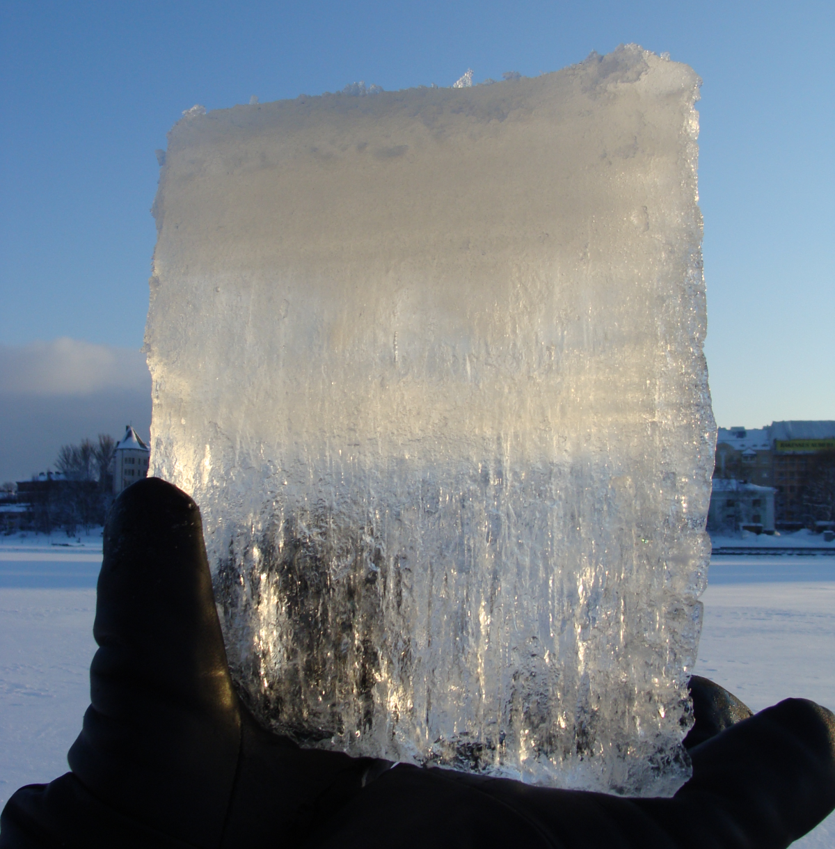Upper part of the ice cube is white and lower part transparent.