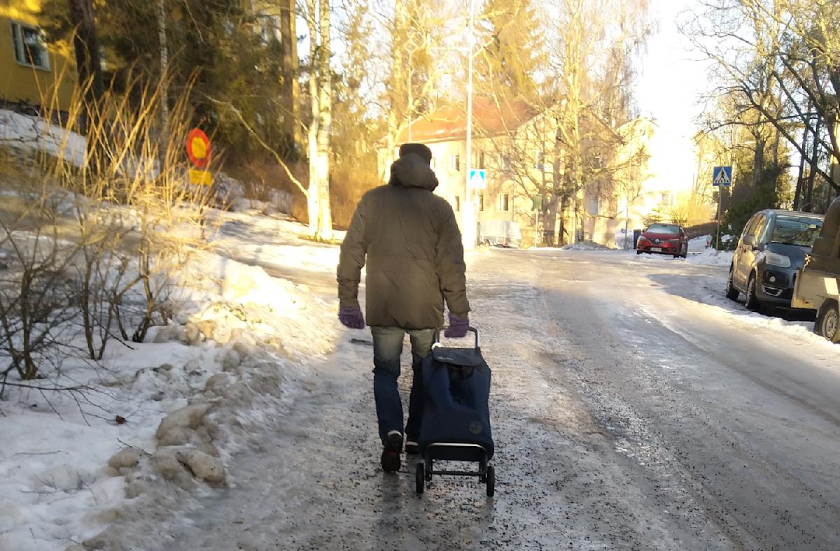icy sidewalk and a man pulls shopping bag.