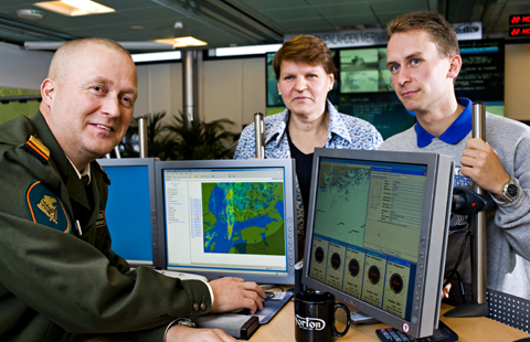 Two meteorologist and a border guard are watching weather forecast.