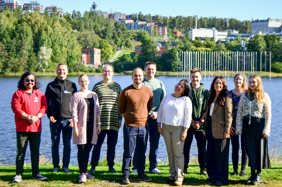 Members of the atmospheric modeling group outside on a summy day in front of the lake.