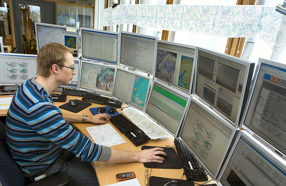 When working, meteorologist is surrounded by severall computer displays.