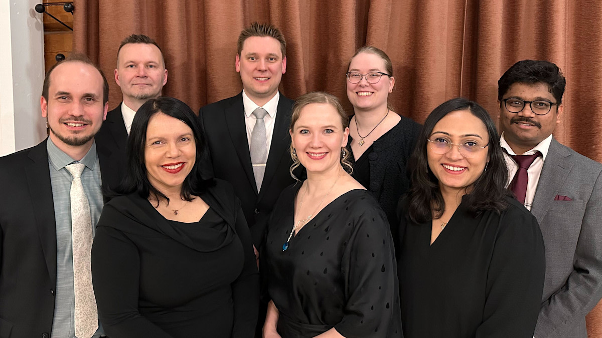 Members of the atmospheric modeling group in formal clothing standing together and smiling.