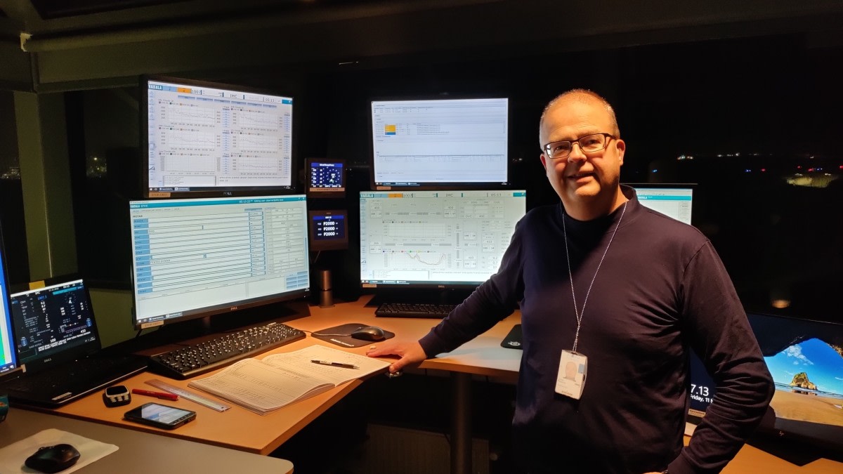 A meteorologist in front of screens. 